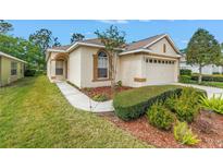 Charming single-story home with a well-manicured lawn and landscaped garden beds at 3215 Banyan Hill Ln, Land O Lakes, FL 34639