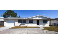 Charming single-story home with a well-maintained front yard, attached garage, and neutral color palette at 3603 Darlington Rd, Holiday, FL 34691