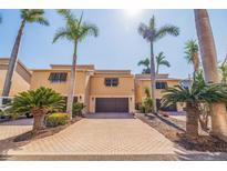 Inviting townhome with a paver driveway, mature landscaping and an attached garage at 487 Pinellas Bayway S # 6, Tierra Verde, FL 33715
