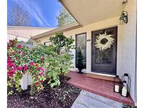 Charming front entrance with brick landing, a decorative wreath, and beautiful bougainvillea at 610 S Woodlands Dr, Oldsmar, FL 34677