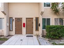 Townhome exterior featuring two front doors, clean tile patio, and a well-maintained facade at 6475 23Rd N St, St Petersburg, FL 33702