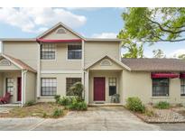 Charming townhome with a red front door, awning, and well-maintained landscaping at 8419 Laurelon Pl, Temple Terrace, FL 33637