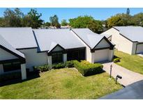 Well-maintained home featuring a manicured lawn, brick driveway and attractive landscaping at 908 Rosewood Ln, Palm Harbor, FL 34684