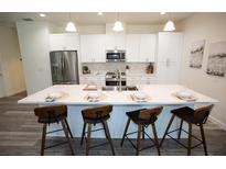 Modern kitchen featuring a large island with barstool seating and stainless steel appliances at 9445 Eldridge Rd, Spring Hill, FL 34608