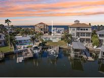Waterfront home with boat docks offering stunning sunset views over the water at 104 Carlyle Cir, Palm Harbor, FL 34683