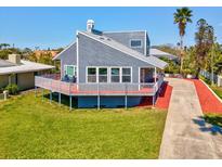 Charming gray home featuring a spacious deck perfect for outdoor relaxation and entertaining at 115 16Th St, Belleair Beach, FL 33786