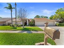 Charming single-story home featuring a well-maintained lawn, mature trees, and a large two car garage at 3442 Beech Trl, Clearwater, FL 33761