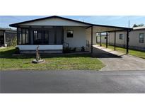 Charming single-story home featuring a carport, screened porch, and well-maintained landscaping at 37542 Pinata Ave, Zephyrhills, FL 33541