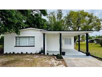 Charming single-story home with a covered porch, manicured lawn, and freshly painted white brick at 4005 W Nassau St, Tampa, FL 33607