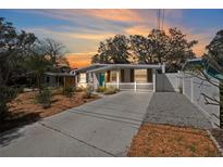 Charming single-story home featuring a manicured lawn, concrete driveway, and a delightful picket fence at 6327 Emerson S Ave, St Petersburg, FL 33707