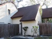 Exterior of the home with a landscaped front yard and a wooden fence at 12611 Touchton Dr # 122, Tampa, FL 33617