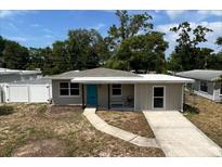 Charming single-story home featuring a bright blue door, well-maintained lawn, and inviting walkway, perfect for first-time buyers at 1312 Tuscola St, Clearwater, FL 33756