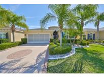 Charming single-story home features tropical landscaping and a patterned driveway at 1647 Emerald Dunes Dr, Sun City Center, FL 33573