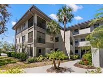 Multi-level condo building showcasing manicured landscaping, tropical palm trees and neutral exterior paint at 2650 Countryside Blvd # B102, Clearwater, FL 33761