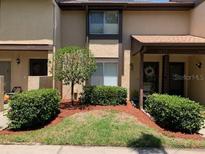 Charming townhome with well-manicured front lawn, mature landscaping, and covered entryway at 3632 Pine Cone Cir, Clearwater, FL 33760