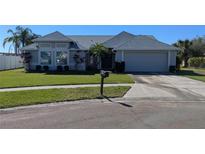 Charming single-story home featuring a manicured lawn, gray paint, and a two-car garage at 2105 Haydon Ct, Brandon, FL 33511