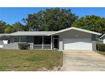 Charming single-story home featuring neutral paint, a white two-car garage, and a well-maintained front lawn at 10126 Bahama Ct, Seminole, FL 33776