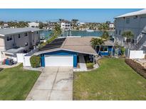 Charming blue home with a well-manicured lawn and a white garage door at 11125 7Th E St, Treasure Island, FL 33706