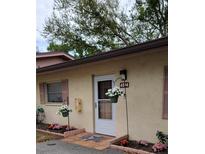 Charming entrance with flowers, muted shutters, and a cream colored stucco exterior at 4594 Mohican Trl # 143, Sarasota, FL 34233
