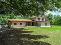 Charming two-story home with a well-maintained lawn and mature trees providing shade at 4902 Five Acre Rd, Plant City, FL 33565