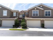Charming townhome featuring a two-car garage, tidy landscaping, and a stucco exterior at 4965 Anniston Cir, Tampa, FL 33647