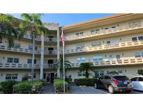 Multi-level condo building with palm trees, updated facade, and well-maintained landscaping at 5725 80Th N St # 107, St Petersburg, FL 33709