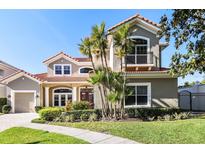 Charming two-story home with a terracotta roof, balcony, manicured lawn, and lush landscaping at 601 Viento De Avila, Tampa, FL 33613