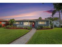 Charming single-story home featuring a well-maintained lawn, inviting front porch, and vibrant landscaping with a brick walkway at 6727 Burlington N Ave, St Petersburg, FL 33710