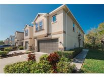 Stylish townhome featuring a stucco exterior, manicured landscaping, and attached two-car garage at 6732 Rocky Park St, Tampa, FL 33625