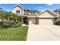 Beautiful two-story home featuring a well-manicured lawn, a two-car garage, and stone accents at 10220 Deercliff Dr, Tampa, FL 33647