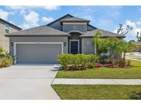 Charming single-Gathering home with a well-manicured lawn and attached two-car garage at 1050 Davis Heather Cir, Seffner, FL 33584