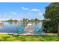 Beautiful waterfront view of the backyard dock featuring two aqua chairs perfect for relaxing by the water at 292 Sunlit Cove Ne Dr, St Petersburg, FL 33702