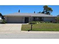 Charming single-story home with a well-manicured lawn and gray exterior paint scheme at 3122 Egret Ter, Safety Harbor, FL 34695