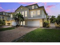Charming two-story home with brick driveway, white garage doors and a balcony at 315 64Th St, Holmes Beach, FL 34217