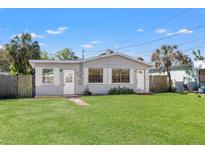 Charming single-story home with a well-manicured front lawn and tropical landscaping at 3256 Roxborough Ave, Clearwater, FL 33762