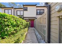 Charming townhome with a colorful entrance, complemented by lush greenery and a well-maintained walkway at 440 Woods Landing Trl, Oldsmar, FL 34677