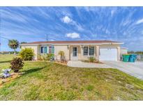 Charming single-story home with a well-maintained lawn and a paved walkway leading to the front door at 9150 Arrid Cir, Port Charlotte, FL 33981