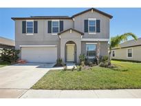 Charming two-story home featuring a well-manicured lawn and inviting front entrance at 11218 Sage Canyon Dr, Riverview, FL 33578
