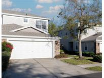 Charming home featuring a two-car garage, stone accents, and well-maintained landscaping at 19227 Stone Hedge Dr, Tampa, FL 33647