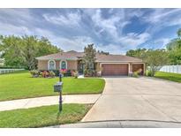 Charming single-story home with a well-manicured lawn, mature landscaping, and a three car garage at 3217 Partridge Point Trl, Valrico, FL 33596