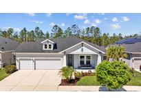 Charming single-story home featuring a 2-car garage, inviting front porch, and manicured landscaping at 3966 Tour Trce, Land O Lakes, FL 34638