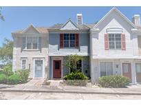 Charming townhome featuring colorful exterior with landscaped garden, and visible unit numbers at 5704 Bratton Dr # 2, Tampa, FL 33617