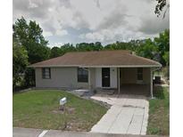 Single-story home featuring a cozy carport and well-maintained front lawn at 7056 Spring Hill Dr, Spring Hill, FL 34606