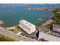 Aerial view of a waterfront apartment building with boat docks, parking and a view of the bay at 100 Bluff View Dr # 409C, Belleair Bluffs, FL 33770