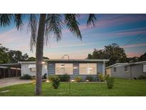 Charming single-story home featuring a well-manicured lawn and mature palm tree at 11313 104Th St, Largo, FL 33773