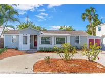 Charming single-story home featuring a well-manicured front yard, light gray exterior, and brick accents around the entry at 129 94Th Ave, Treasure Island, FL 33706