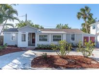 Charming single-story home featuring a well-manicured front yard and a quaint covered porch at 129 94Th Ave, Treasure Island, FL 33706