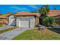 Charming home featuring an attached one-car garage and well-maintained lawn at 1908 Bayshore Ct, Safety Harbor, FL 34695