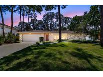Charming single-story home featuring stone accents, a well-manicured lawn, and mature trees at 3034 Gull Pl, Clearwater, FL 33762