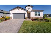 Inviting home with a two-car garage, well-kept lawn, and tasteful stone accents at 34329 Evergreen Hill Ct, Wesley Chapel, FL 33545